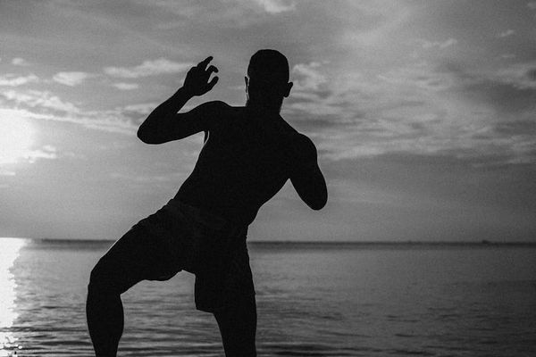 Silhouette of a man in a balancing strength pose.